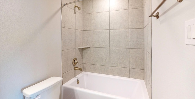 bathroom with toilet and tiled shower / bath combo