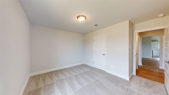 unfurnished bedroom featuring light carpet and a closet