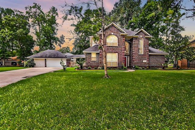 traditional-style house featuring an attached garage, brick siding, driveway, and a front lawn