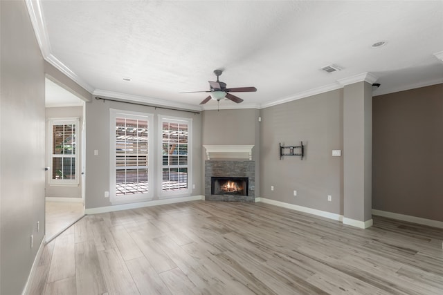 unfurnished living room featuring ceiling fan, light hardwood / wood-style floors, a fireplace, and ornamental molding