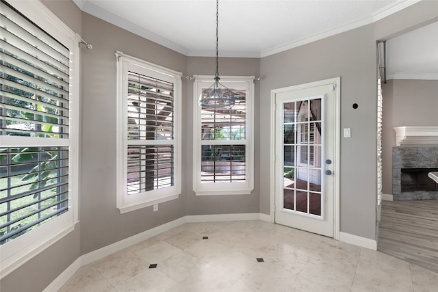 unfurnished dining area featuring plenty of natural light, ornamental molding, light tile floors, and a fireplace