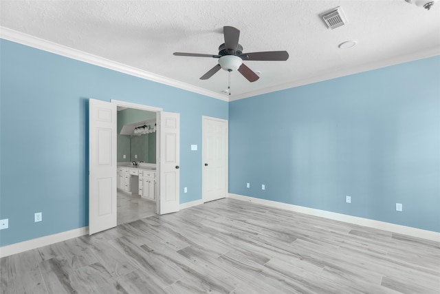 unfurnished bedroom with crown molding, a textured ceiling, ensuite bath, ceiling fan, and light tile floors