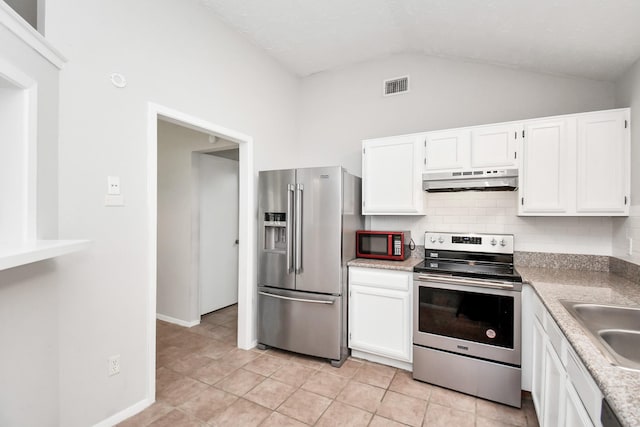 kitchen with appliances with stainless steel finishes, sink, light tile patterned floors, high vaulted ceiling, and white cabinetry