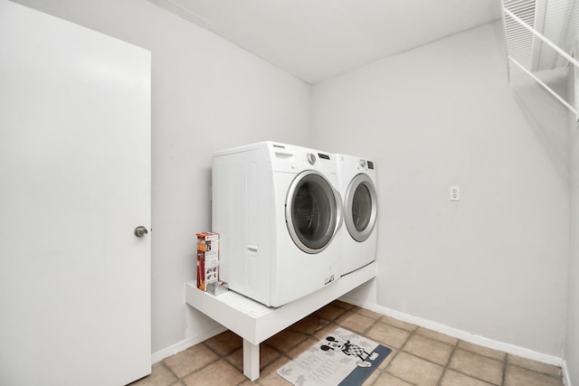 clothes washing area with light tile patterned floors and washing machine and clothes dryer