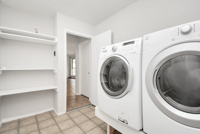 laundry room featuring light tile patterned floors and washing machine and clothes dryer