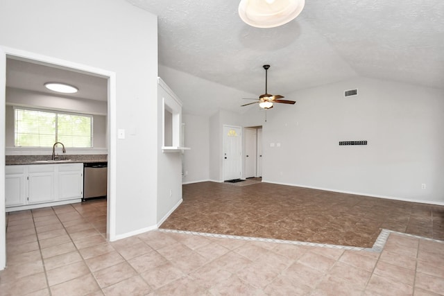 unfurnished living room featuring ceiling fan, sink, a textured ceiling, vaulted ceiling, and light tile patterned flooring