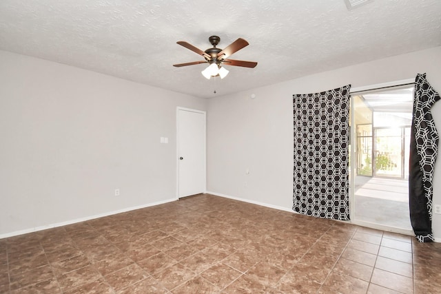 unfurnished room with ceiling fan and a textured ceiling