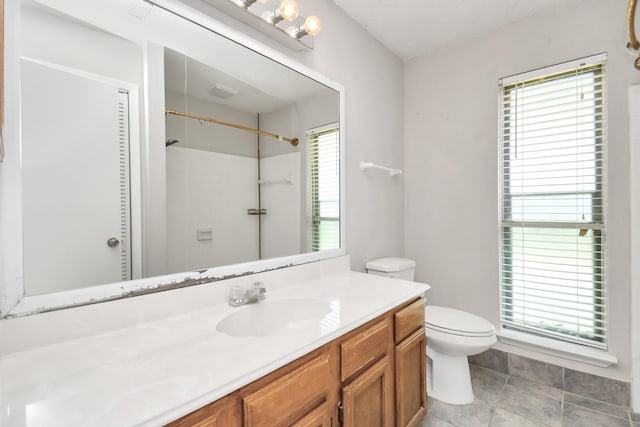 bathroom featuring plenty of natural light, vanity, and toilet