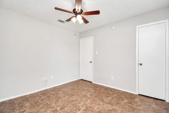 empty room featuring ceiling fan and a textured ceiling