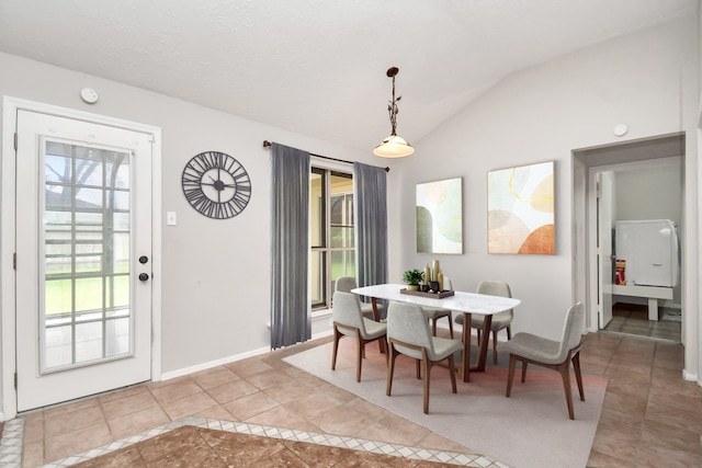 dining area featuring light tile patterned floors and lofted ceiling