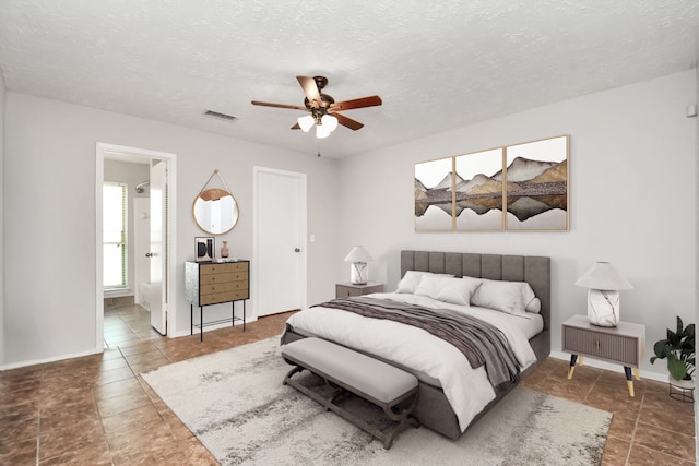 bedroom featuring ceiling fan, a textured ceiling, and connected bathroom