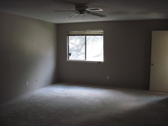 carpeted empty room featuring ceiling fan