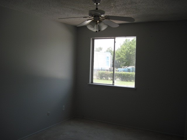 unfurnished room with a textured ceiling and ceiling fan