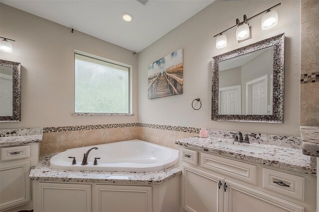 bathroom featuring a washtub and vanity