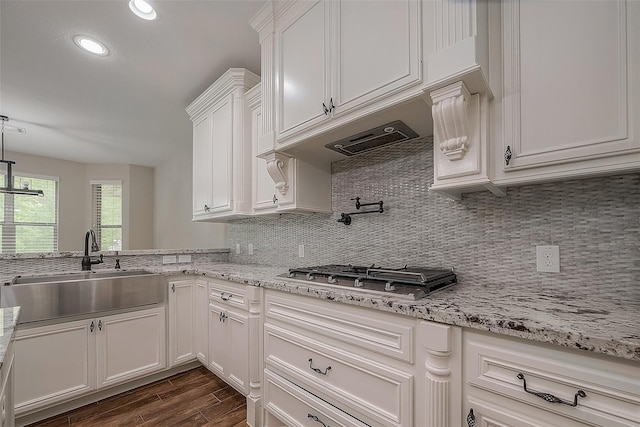 kitchen featuring hanging light fixtures, sink, dark hardwood / wood-style floors, white cabinetry, and stainless steel gas cooktop