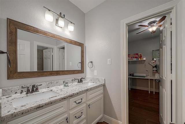 bathroom with hardwood / wood-style floors, ceiling fan, and vanity