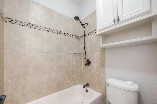 bathroom featuring toilet and tiled shower / bath