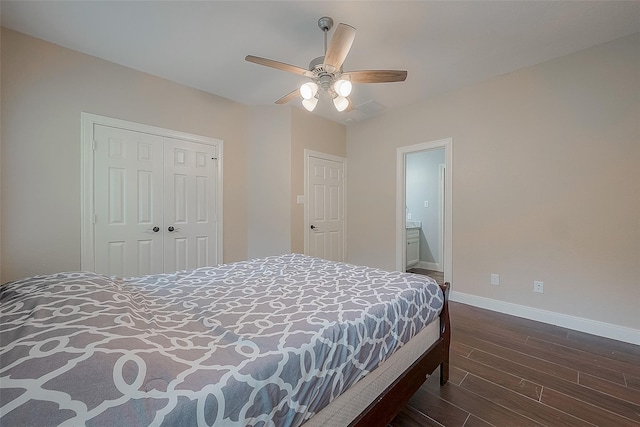 bedroom featuring ceiling fan, ensuite bath, dark wood-type flooring, and a closet