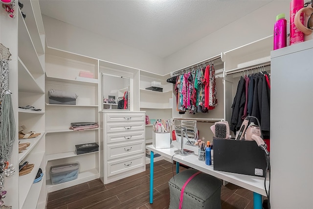 walk in closet with dark wood-type flooring