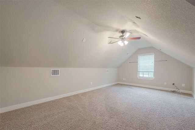 bonus room with carpet flooring, ceiling fan, a textured ceiling, and vaulted ceiling