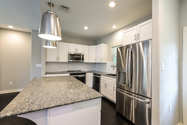 kitchen featuring stainless steel appliances, backsplash, white cabinetry, and hanging light fixtures