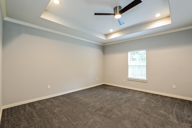 carpeted empty room featuring ceiling fan, a tray ceiling, and ornamental molding