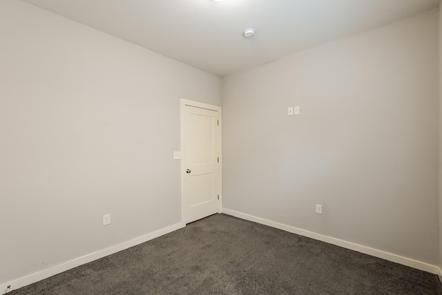 empty room featuring dark colored carpet