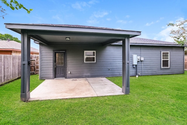 back of property with a yard and a patio