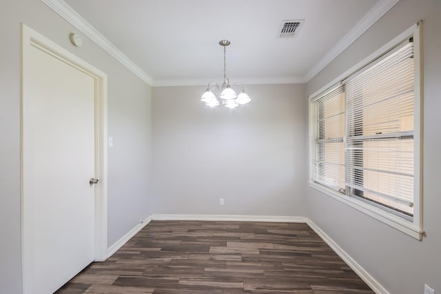 spare room featuring dark hardwood / wood-style floors, crown molding, and a notable chandelier