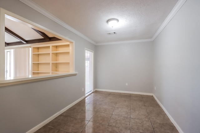 spare room with tile patterned flooring, a textured ceiling, built in features, and crown molding