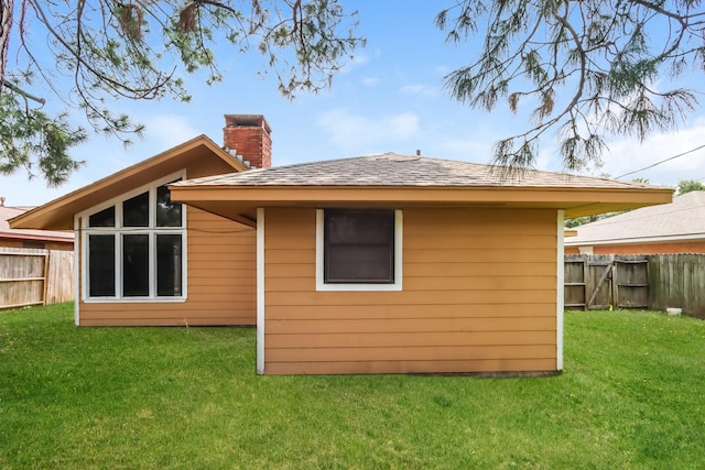 rear view of property featuring a lawn