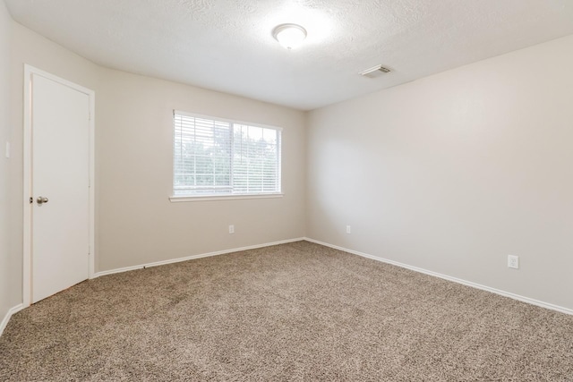 unfurnished room with carpet floors and a textured ceiling