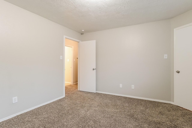 carpeted spare room featuring a textured ceiling