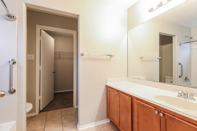 bathroom featuring tile patterned floors, a shower, vanity, and toilet