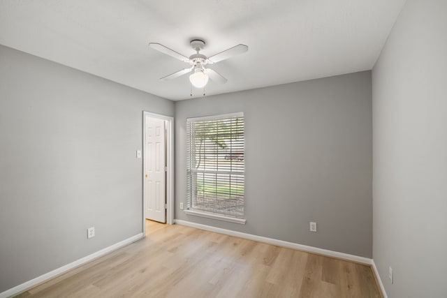 spare room featuring a ceiling fan, baseboards, and wood finished floors