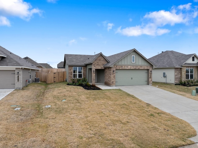 view of front of house with a garage, central AC, and a front lawn