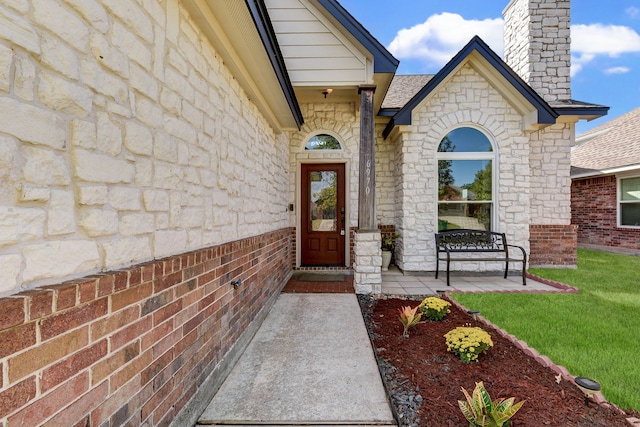 entrance to property featuring a lawn