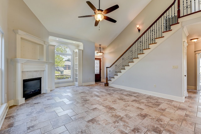 unfurnished living room featuring high vaulted ceiling and ceiling fan