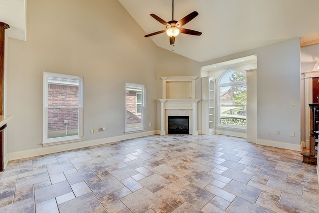 unfurnished living room with ceiling fan and high vaulted ceiling