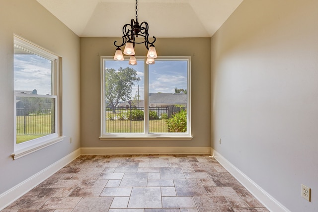 unfurnished dining area featuring lofted ceiling and a chandelier