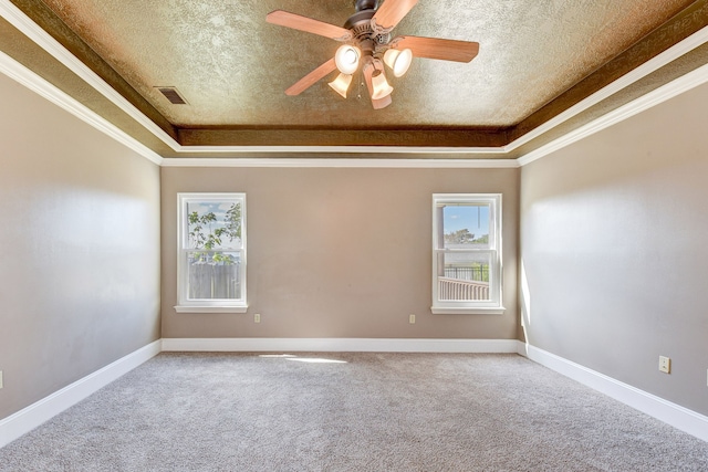 unfurnished room with a tray ceiling, a textured ceiling, and ornamental molding