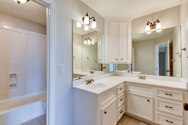 bathroom featuring vanity, toilet, tile patterned flooring, and a bathing tub