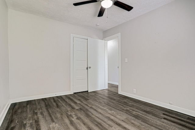 unfurnished room with ceiling fan, dark wood-type flooring, and a textured ceiling