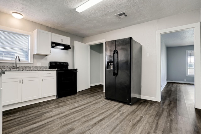 kitchen featuring light stone countertops, white cabinetry, sink, dark hardwood / wood-style floors, and black appliances