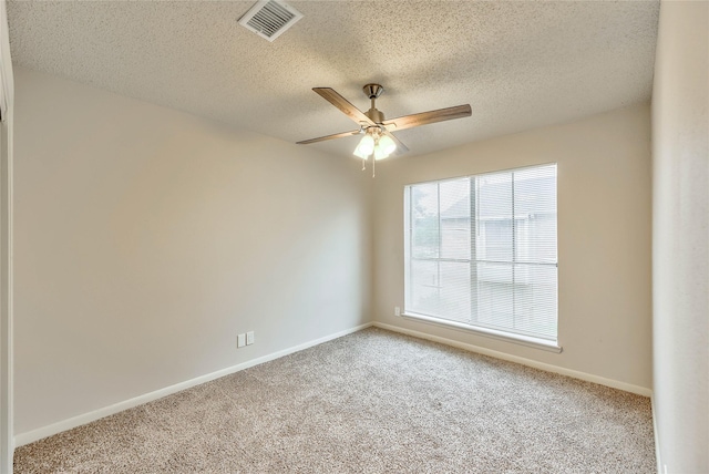 carpeted spare room featuring a textured ceiling and ceiling fan