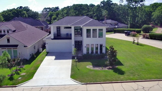 view of front of home with a garage, a balcony, and a front lawn