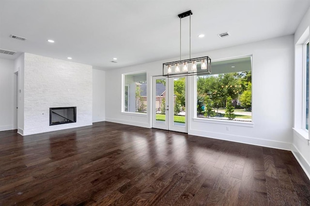 unfurnished living room featuring visible vents, a fireplace, and dark wood-type flooring