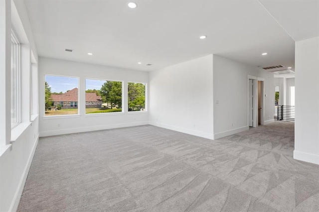 spare room featuring recessed lighting, light colored carpet, visible vents, and baseboards