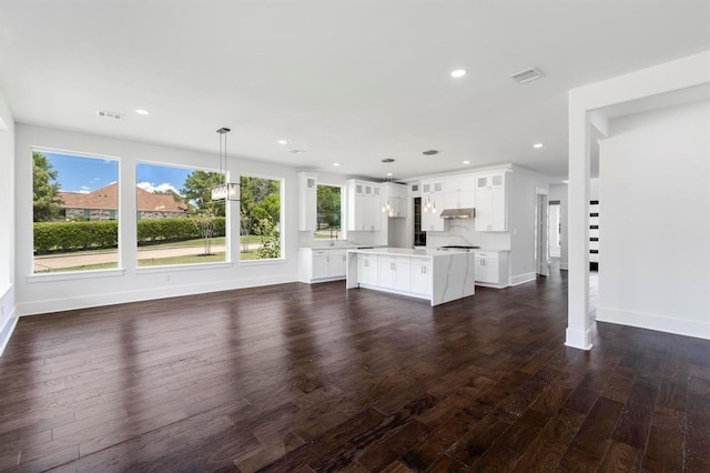 unfurnished living room featuring recessed lighting, visible vents, baseboards, and dark wood-style floors