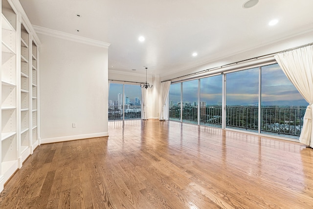 unfurnished living room featuring floor to ceiling windows, ornamental molding, and wood-type flooring